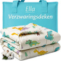 Ella verzwaringsdeken met dinoprint in crème, gevouwen naast een turquoise draagtas.