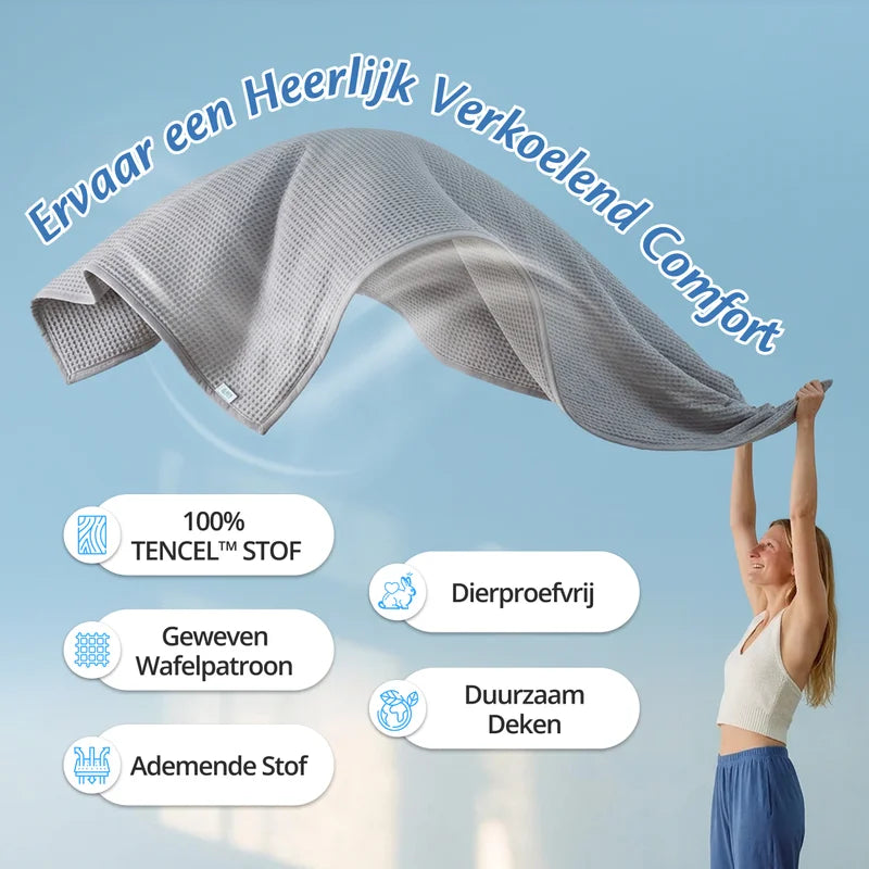 Vrouw houdt een grijze Ella Koeldeken hoog in de lucht, met kenmerken: 100% TENCEL stof, geweven wafelpatroon, ademende stof, dierproefvrij en duurzaam