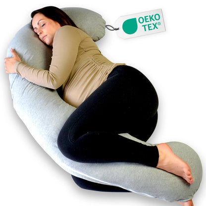Vrouw ligt comfortabel op een groot grijs kussen van Ella Sleeps J - Shape Katoen, perfect voor zwangerschapsondersteuning.