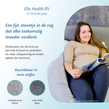 Een vrouw leest een boek op de bank, met een Ella Sleeps zwangerschapskussen voor extra comfort.