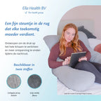 Vrouw op bed met een tablet, comfortabel leunend tegen een zwangerschapskussen van Ella Sleeps.