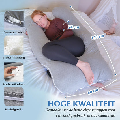 Een vrouw ligt op een bed met een kussen en een zwangerschapskussen van Ella Sleeps, met sterke ritssluiting en dubbel gestikt.