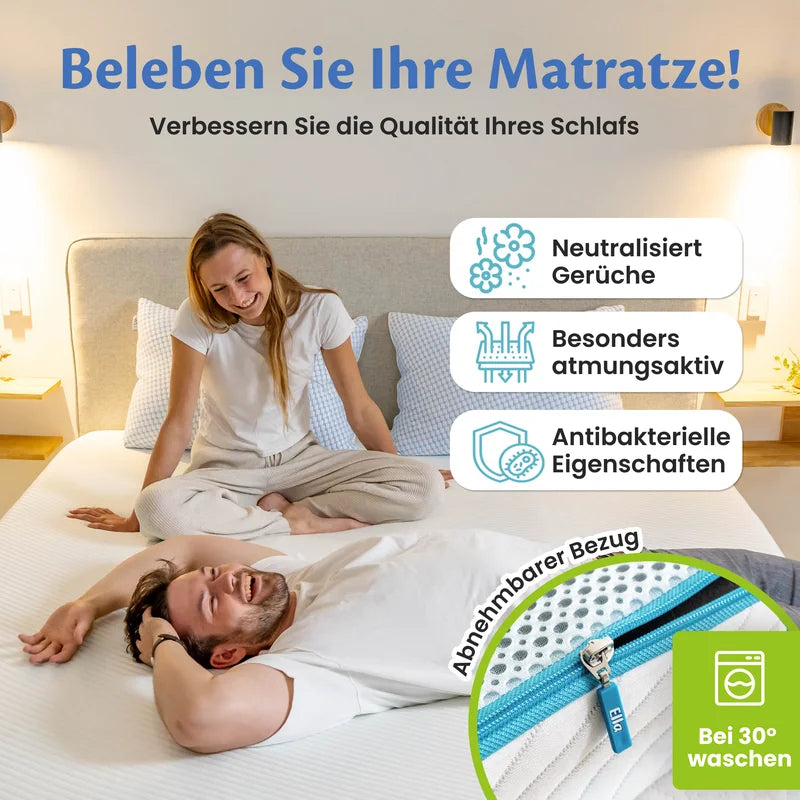 Frau sitzt im Schneidersitz auf dem Bett, daneben drei Hinweisfelder zu Geruchsneutralisierung, Atmungsaktivität und antibakteriellen Eigenschaften sowie der abnehmbare Reißverschlussbezug, waschbar bei 30 °C