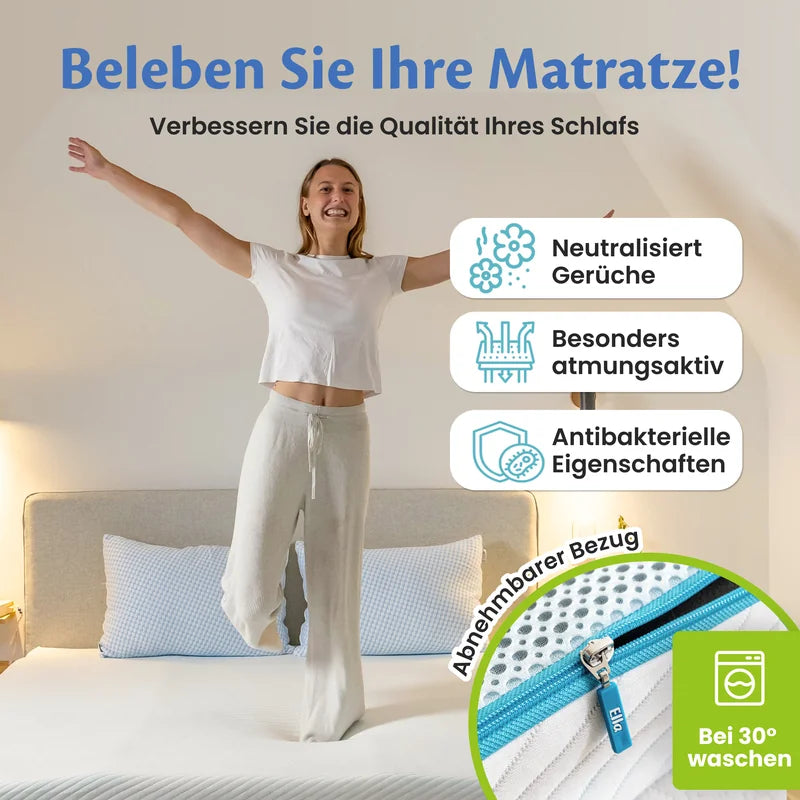 Frau sitzt im Schneidersitz auf dem Bett, daneben drei Hinweisfelder zu Geruchsneutralisierung, Atmungsaktivität und antibakteriellen Eigenschaften sowie der abnehmbare Reißverschlussbezug, waschbar bei 30 °C