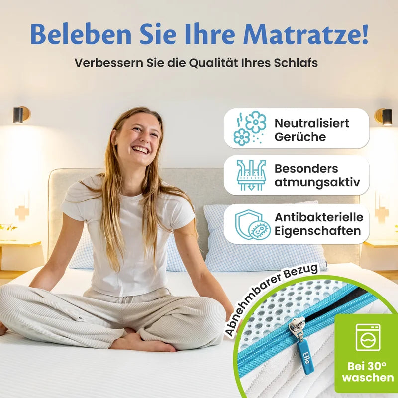 Frau sitzt im Schneidersitz auf dem Bett, daneben drei Hinweisfelder zu Geruchsneutralisierung, Atmungsaktivität und antibakteriellen Eigenschaften sowie der abnehmbare Reißverschlussbezug, waschbar bei 30 °C