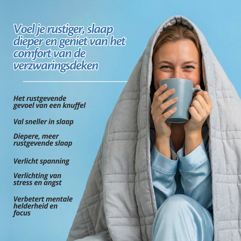 Vrouw ontspant met een warme drank onder de grijze Ella verzwaringsdeken, met voordelen op een rij.
