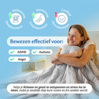 Vrouw gewikkeld in de grijze Ella verzwaringsdeken; bewezen effectief bij ADHD, autisme en angst.